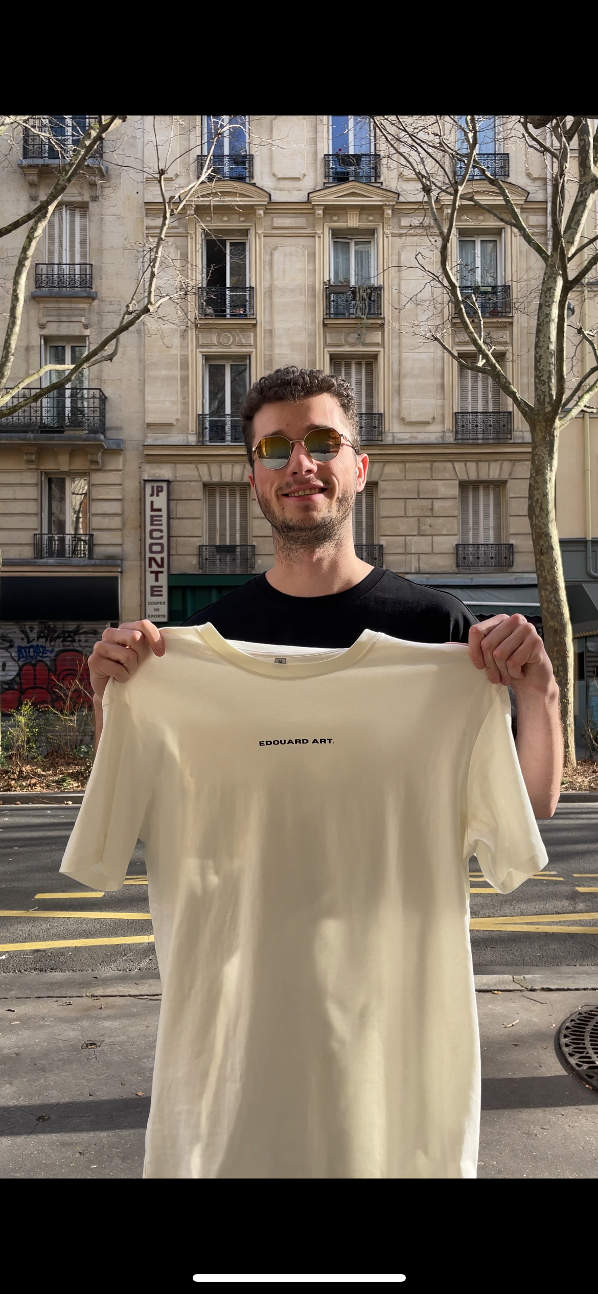 Image d'un mannequin, portant le T-shirt  noir étonnant dans sa main, en T-shirt blanc de la collection New York